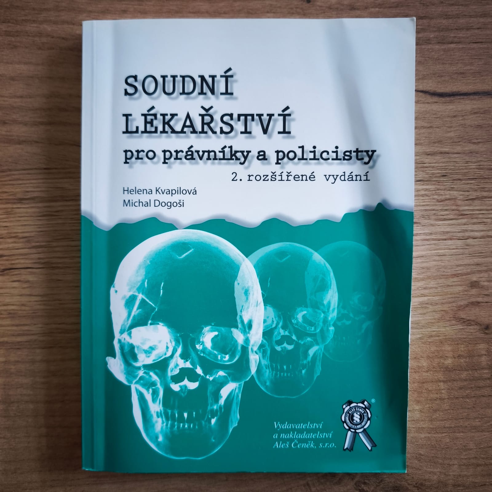 Původní fotografie přední obálky knihy Soudní lékařství pro právníky a policisty s lehkým zvlněním obálky.